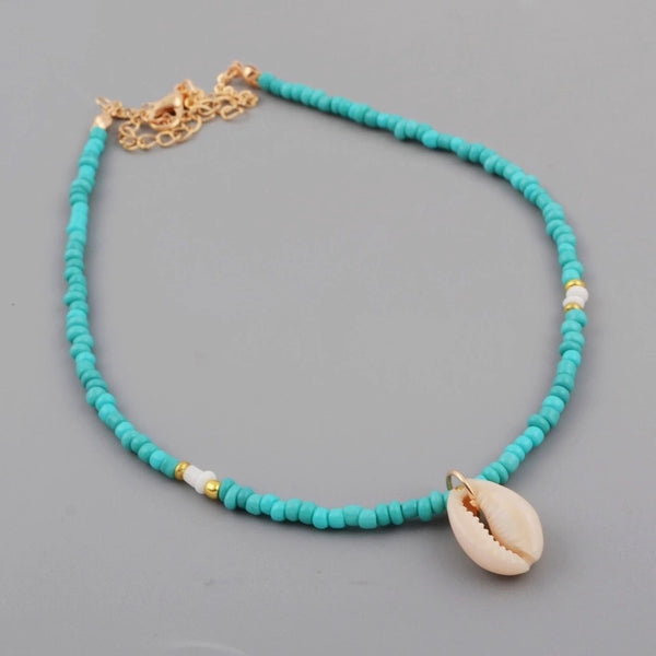 Collier en perles rocaille bleues et dorées et coquillage Cauri