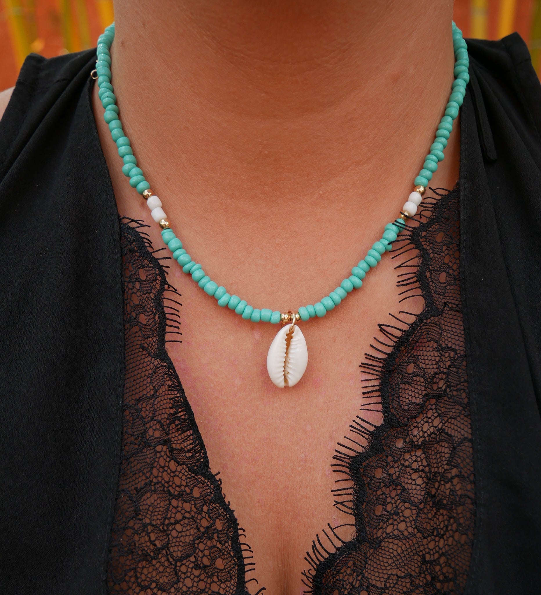Collier en perles rocaille bleues et dorées et coquillage Cauri